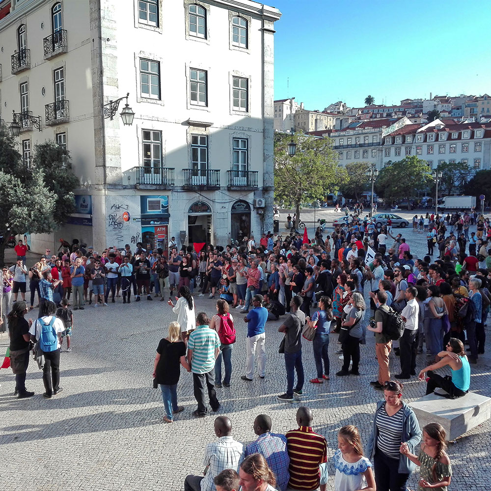 Around two hundred people gathered in a square and listening to speeches.